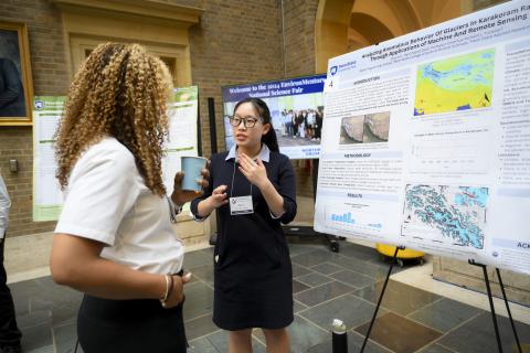 Young woman presenting her poster to another woman