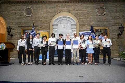 Group of award winning students standing on stage with their award certificates 