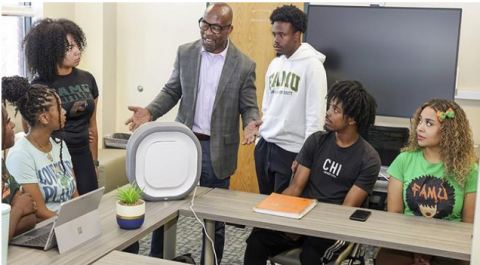 Dean Ibeanusi speaks with a group of students